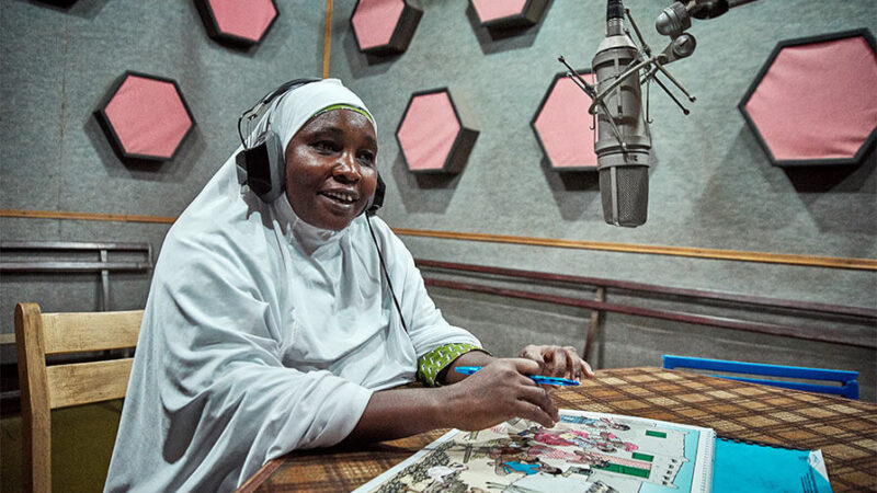 Woman speaks into a microphone.